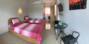 - une chambre avec un lit, une table et une chaise dans l'établissement บ้านพักณัฐรินีย์, à Sam Phran