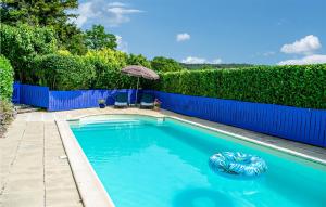 ein Pool mit einem blauen Zaun und einem Sonnenschirm in der Unterkunft Awesome Home In Chaumussay With Heated Swimming Pool in Chaumussay