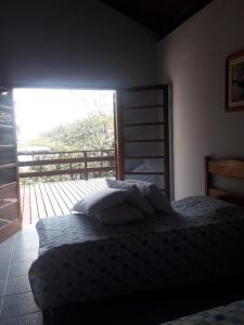 una camera da letto con un letto e una grande finestra di Linda Costeira na Praia do Julião-Ilhabela a Ilhabela