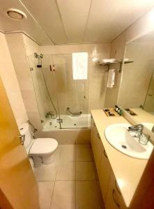 een badkamer met een toilet, een douche en een wastafel bij Okeanos Bmarina in Herzliyya B