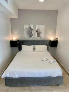 a bedroom with a bed with three pictures on the wall at Okeanos Bmarina in Herzliyya B