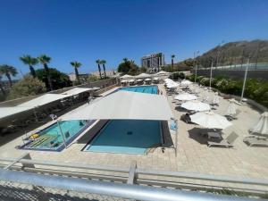 uma piscina com guarda-sóis e cadeiras e uma piscina em Okeanos Bmarina em Herzliya B