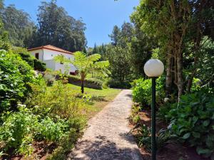 un jardin avec un chemin menant à une maison dans l'établissement Cantinho Rural, à Camacha