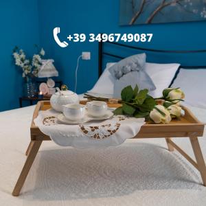 - Mesa de centro con 2 tazas de té y flores en una cama en Flower House, en Santo Stefano di Camastra