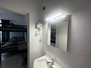 a bathroom with a sink and a mirror and a bed at Zeus in Cluj-Napoca