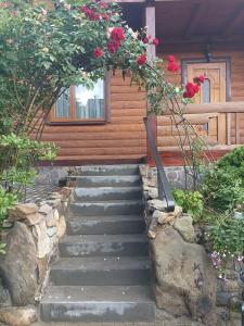 a set of stairs in front of a house with roses at Котедж "Хата Рибака" in Kosiv