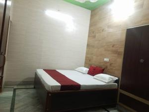 ein Schlafzimmer mit einem Bett mit roten Kissen in der Unterkunft 4BHK Shruti Home Stay in Varanasi