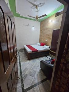 ein Schlafzimmer mit einem Bett und einem Stuhl darin in der Unterkunft 4BHK Shruti Home Stay in Varanasi