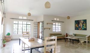 ein Wohnzimmer mit einem Tisch und einem Sofa in der Unterkunft JINJA HOUSE in Jinja