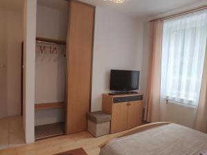 a bedroom with a bed and a television on a cabinet at MAGNOLIA Duszniki Zdrój in Duszniki Zdrój