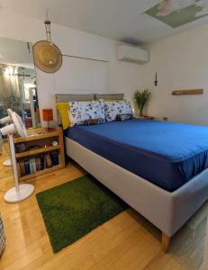 - une chambre avec un lit bleu et un tapis vert dans l'établissement appartamento centro storico, à Monfalcone