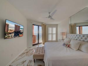 1 dormitorio blanco con 1 cama grande y 1 sofá en Seachase 803W by Vacation Homes Collection en Orange Beach