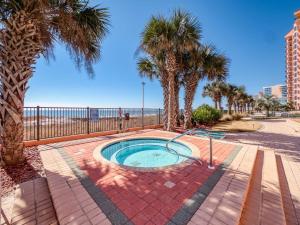 una pequeña piscina con palmeras y la playa en Seachase 803W by Vacation Homes Collection en Orange Beach