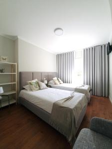 um quarto com 2 camas e uma janela em Sonetos - Guest House no Porto
