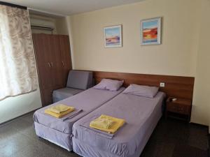 1 dormitorio con 2 camas y toallas amarillas. en Цар Калоян en Primorsko