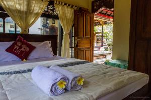 a bedroom with a bed with two pillows on it at Ubud Tri Upasedana House 2 in Tegalalang
