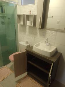 a bathroom with a sink and a glass shower at Casa de Praia in Balneário Gaivotas