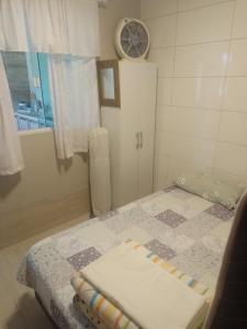 um pequeno quarto com uma cama e uma janela em Casa de Praia em Balneário Gaivotas