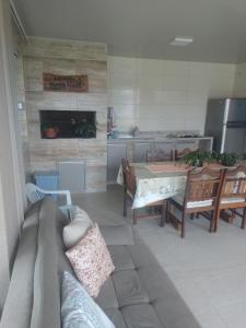 uma sala de estar com um sofá e uma mesa em Casa de Praia em Balneário Gaivotas
