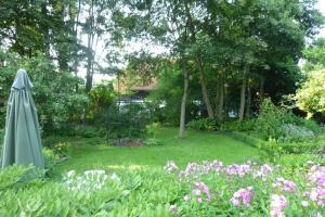 a garden with an umbrella and some flowers at Ferienwohnung Beim Bienagassl in Waldsassen