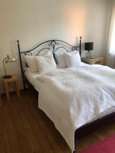 - une chambre dotée d'un lit blanc avec des draps et des oreillers blancs dans l'établissement Ferienwohnung Beim Bienagassl, à Waldsassen