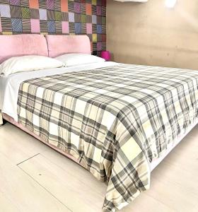 una cama con una manta a cuadros encima en Santa Chiara Apartment, en Nápoles