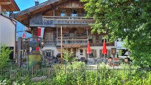 a wooden house with red umbrellas in front of it at ALMRAUSCH in Ebbs