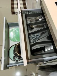 uma gaveta com utensílios numa cozinha em Tiny Nest Homestay - iCity Shah Alam with Free WIFI, 5 minutes to UITM em Kampong Padang Jawa