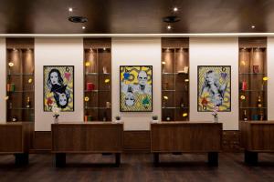 um quarto com pinturas nas paredes e bancos em St Giles London – A St Giles Hotel em Londres