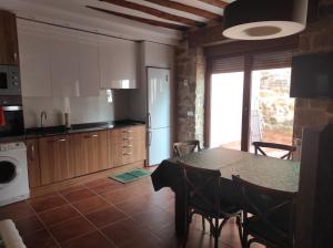 a kitchen with a table and chairs and a kitchen with a stove at Casa Moneo in Briones