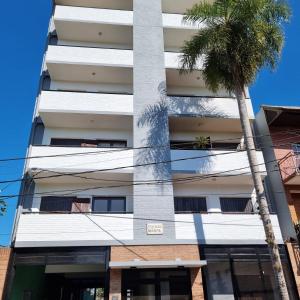 un edificio con una palmera delante de él en Marfil en Posadas