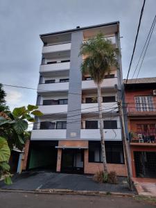 un edificio alto con una palmera delante de él en Marfil en Posadas