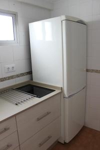 a kitchen with a white refrigerator and a sink at Alojamiento Teja in Arcos de la Frontera