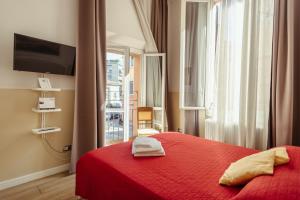 a bedroom with a red bed with a red blanket and a window at Il Tiro Rooms in Bologna