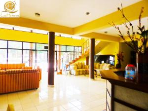 a lobby with yellow walls and couches in a building at Hotel Las Hamacas in La Ceiba