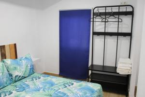 1 dormitorio con 1 cama y puerta azul en Alojamiento Teja, en Arcos de la Frontera