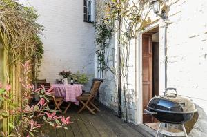 an outdoor patio with a table and a grill at Wixey House in Chipping Campden