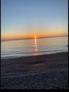 einen Sonnenuntergang am Strand mit Sonnenuntergang über dem Wasser in der Unterkunft Plage du Havre in Le Havre