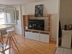 ein Wohnzimmer mit einem Flachbild-TV und eine Küche in der Unterkunft Plage du Havre in Le Havre