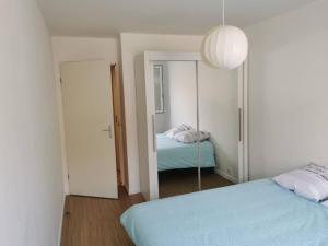 ein Schlafzimmer mit einem blauen Bett und einem Spiegel in der Unterkunft Plage du Havre in Le Havre