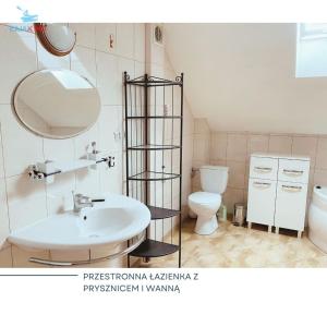 uma casa de banho com um lavatório branco e um WC. em Agroturystyka Włochate Ranczo 