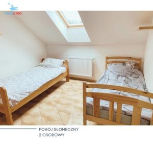 um quarto com 2 camas e uma clarabóia em Agroturystyka Włochate Ranczo 