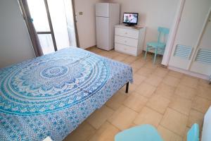 1 dormitorio con 1 cama, vestidor y TV en Monolocale ilporticciolovacanze en Villanova di Ostuni