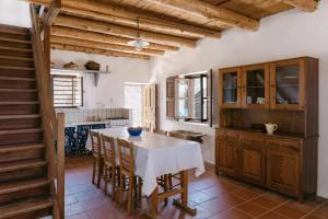 a kitchen with a table and chairs and a staircase at Villa Unica in Yiannioú