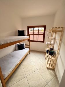 Hostel Passa4 في باسا كواترو: غرفة بسريرين بطابقين ونافذة