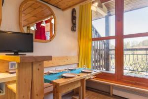 Zimmer mit einem Tisch, einem TV und einem Fenster in der Unterkunft Arcs 1800: 5/6 people Ski Studio view Mont Blanc in Arc 1800