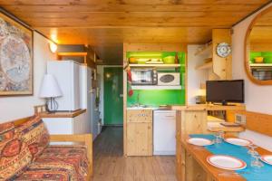eine Küche und ein Wohnzimmer in einem winzigen Haus in der Unterkunft Arcs 1800: 5/6 people Ski Studio view Mont Blanc in Arc 1800