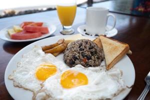 a plate of breakfast food with eggs and toast at BellaVista Suites By Villas Verdes - Samara Beach in Sámara