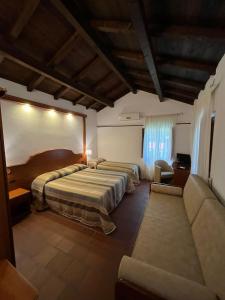 Habitación de hotel con 2 camas y sofá en Agriturismo Cervinace en Oriolo