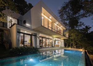 a house with a swimming pool at night at Maxwell Villa Bali in Tabanan +27 photos